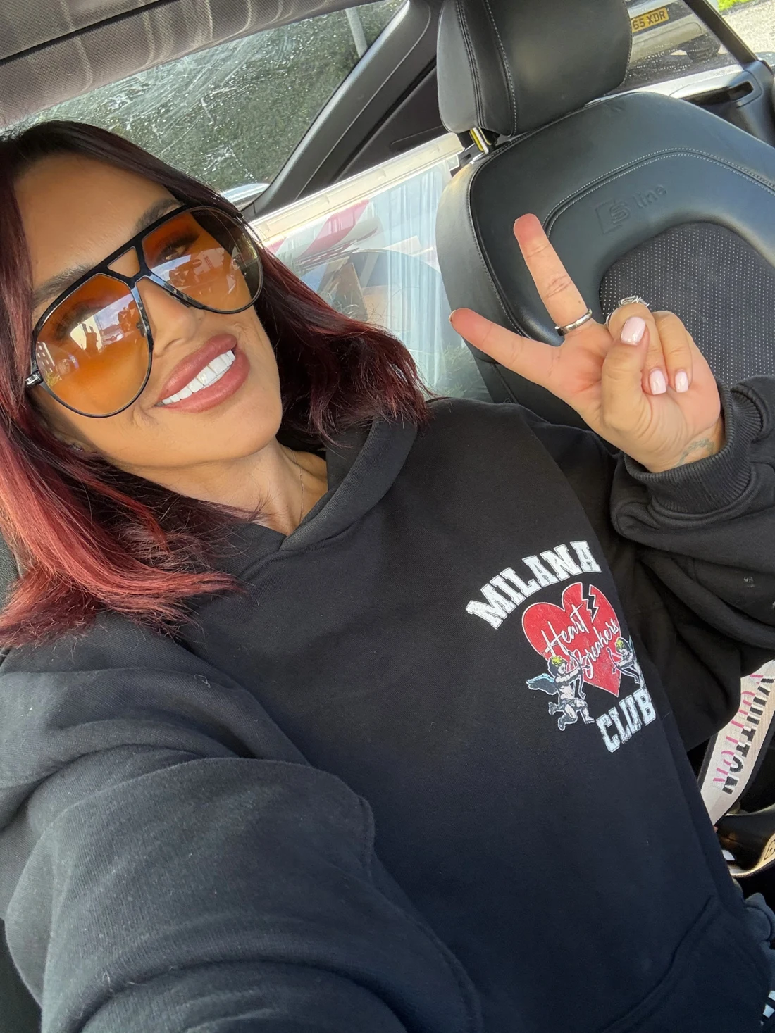 Gemma smiling in sunglasses in a car